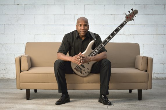 Bassist Nathan East on a sofa with his bass