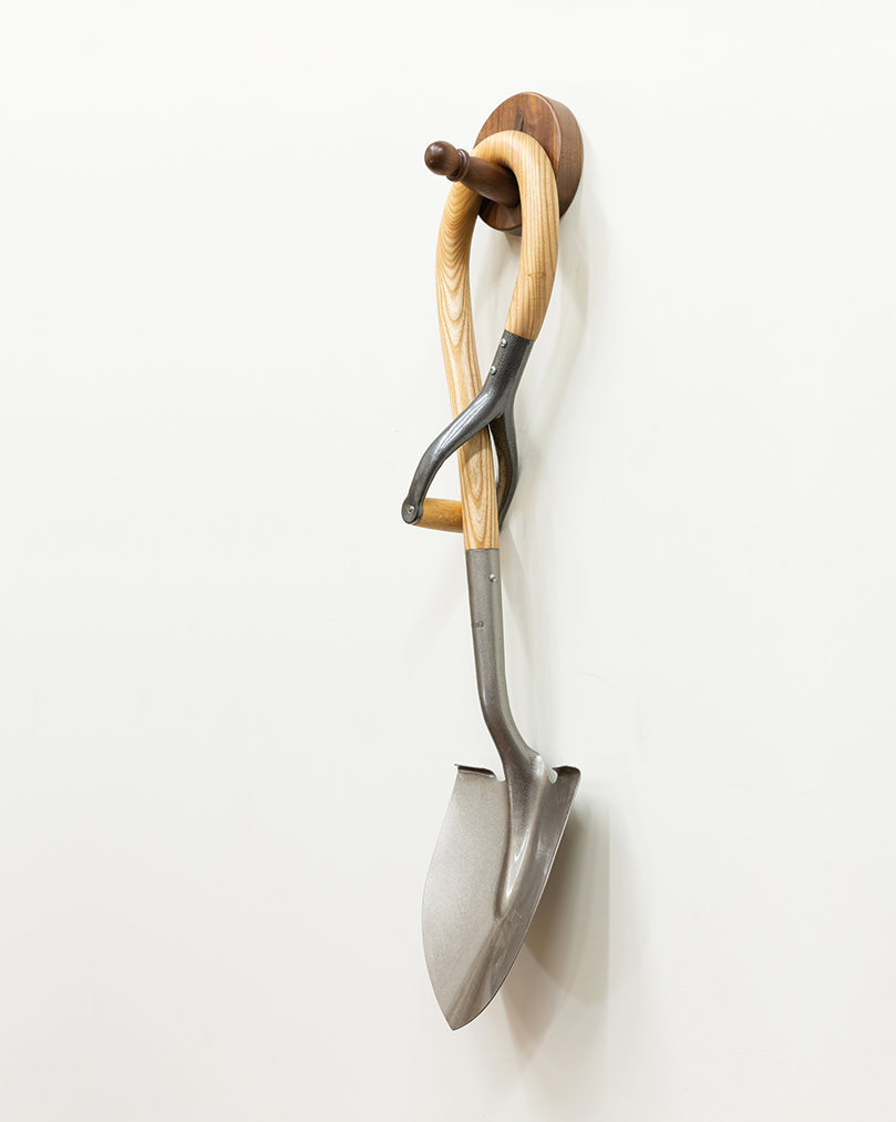 Droopy shovel sculpture hanging on wall