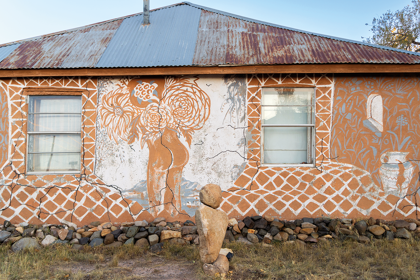 A mural featuring human buttocks formed around a crack in the stucco