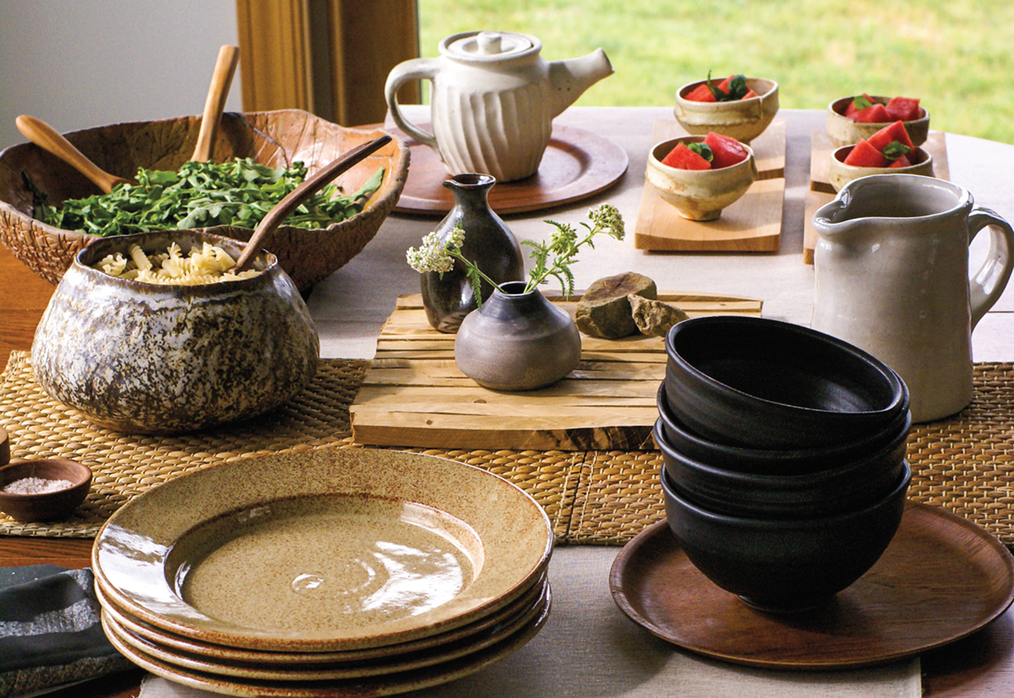 A dining table set for a meal with handmade tableware