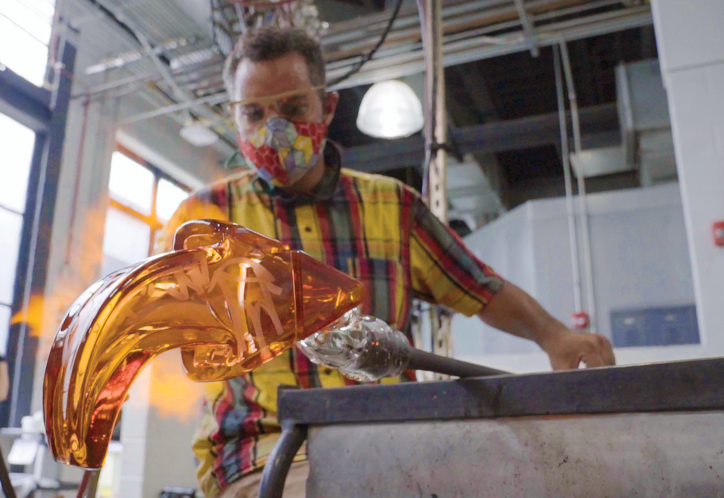 Leo Tecosky forms a graffiti arrow from blown glass.