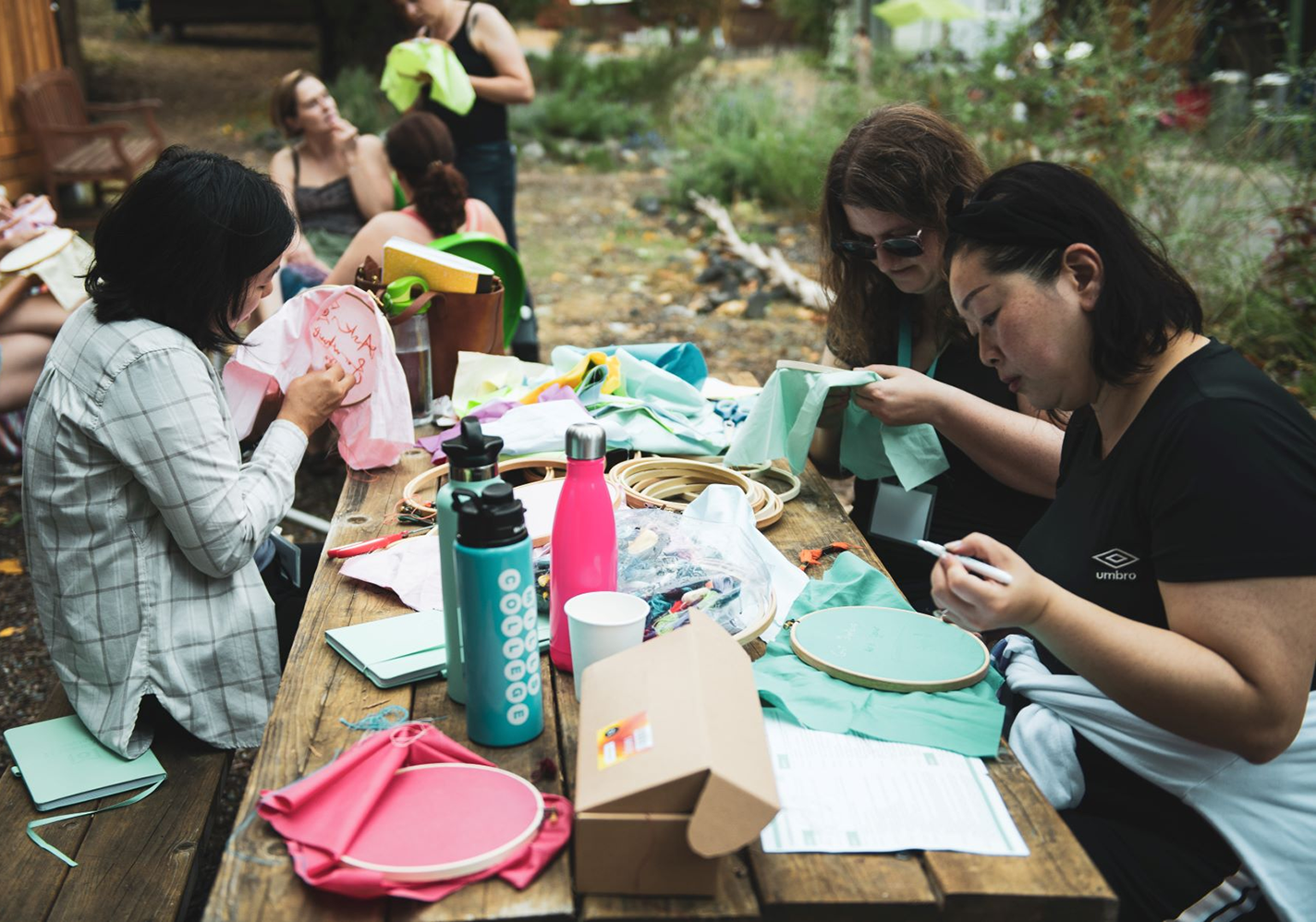 People doing cross-stitch at an outdoor gathering