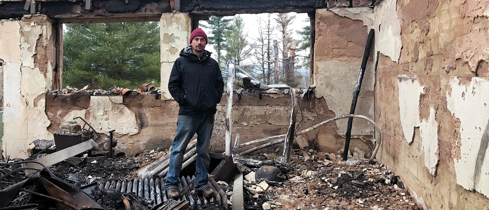 Eric Knoche standing in his burned-down studio.