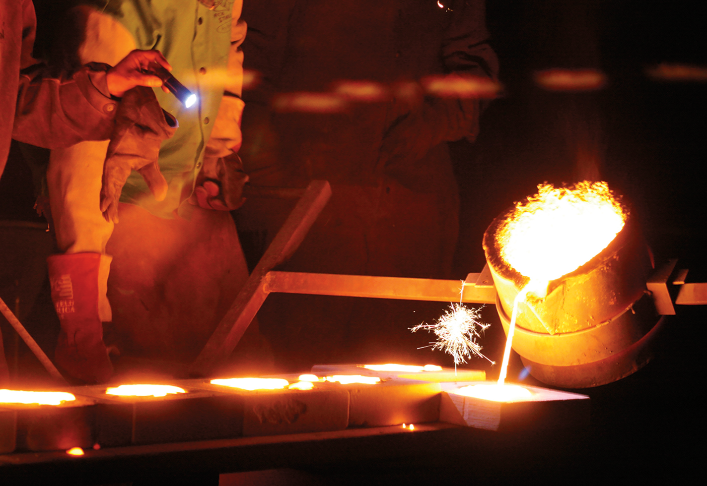 Pouring molten iron into an open-faced mold.