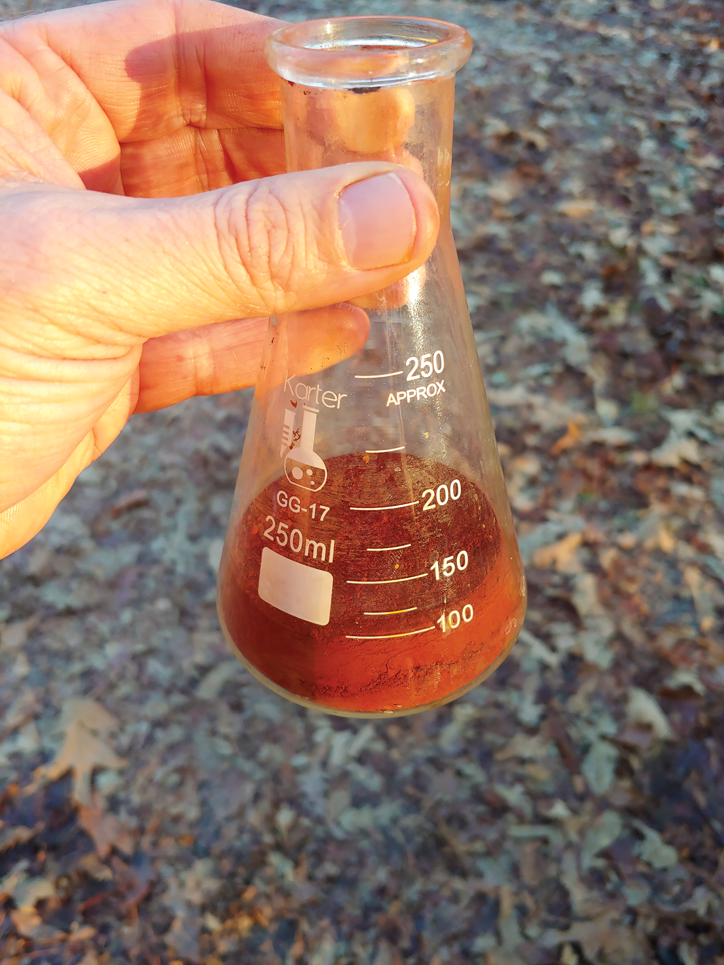 Red iron oxide pigment in a flask.