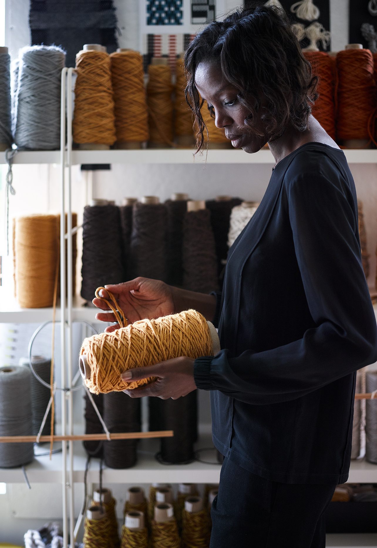 Sylvie Johnson in Merida's studio workshop, handling a cone of yarn.