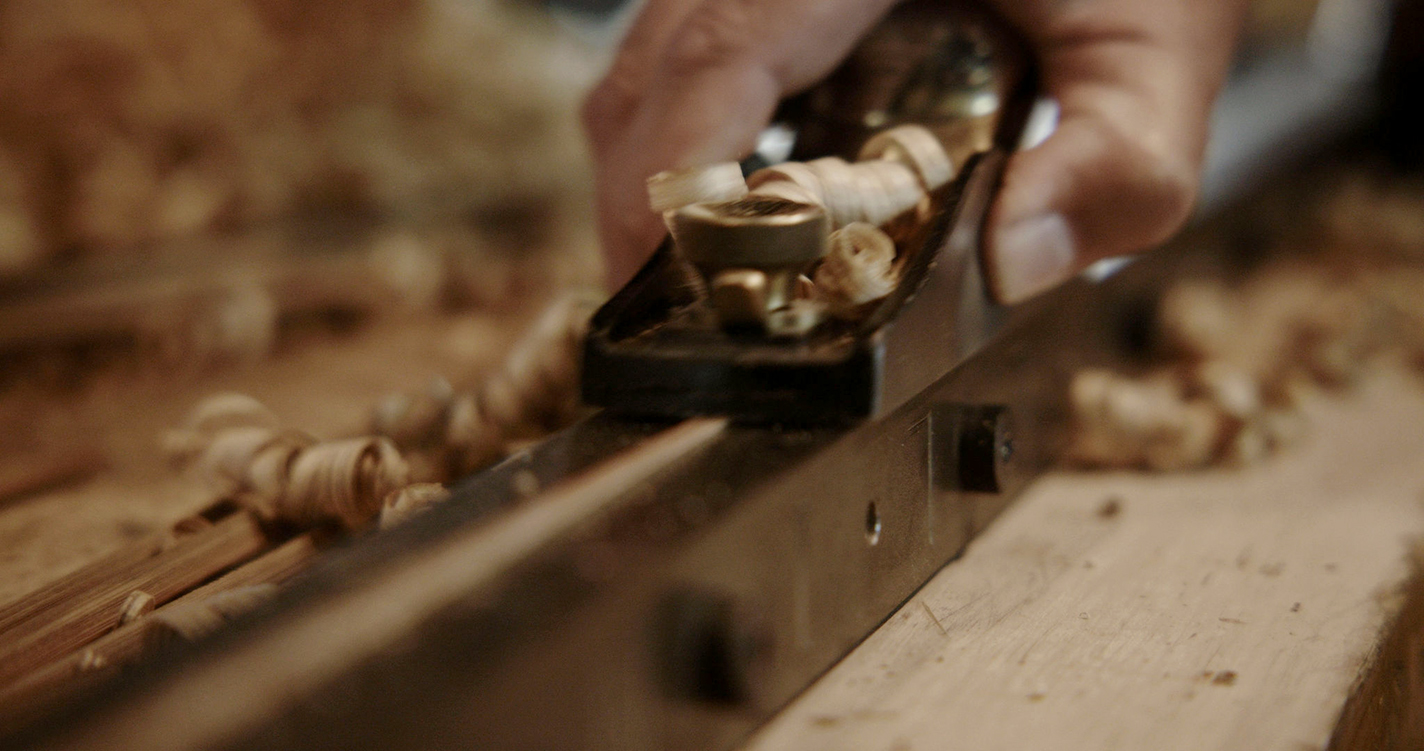 Bill Oyster hand-planes strips cut from a bamboo culm.