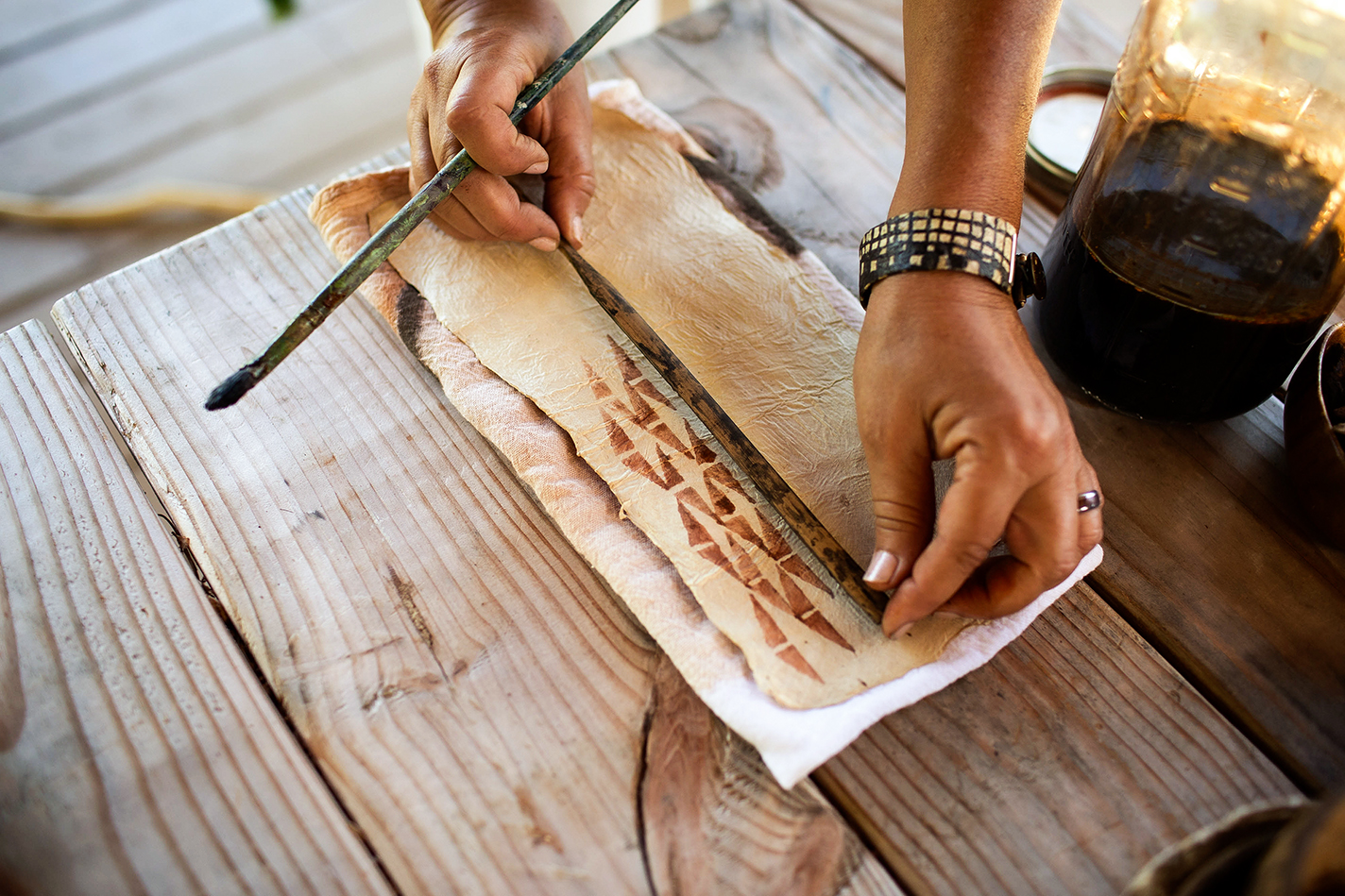 Chang printing on kapa with a traditional stamp and ink
