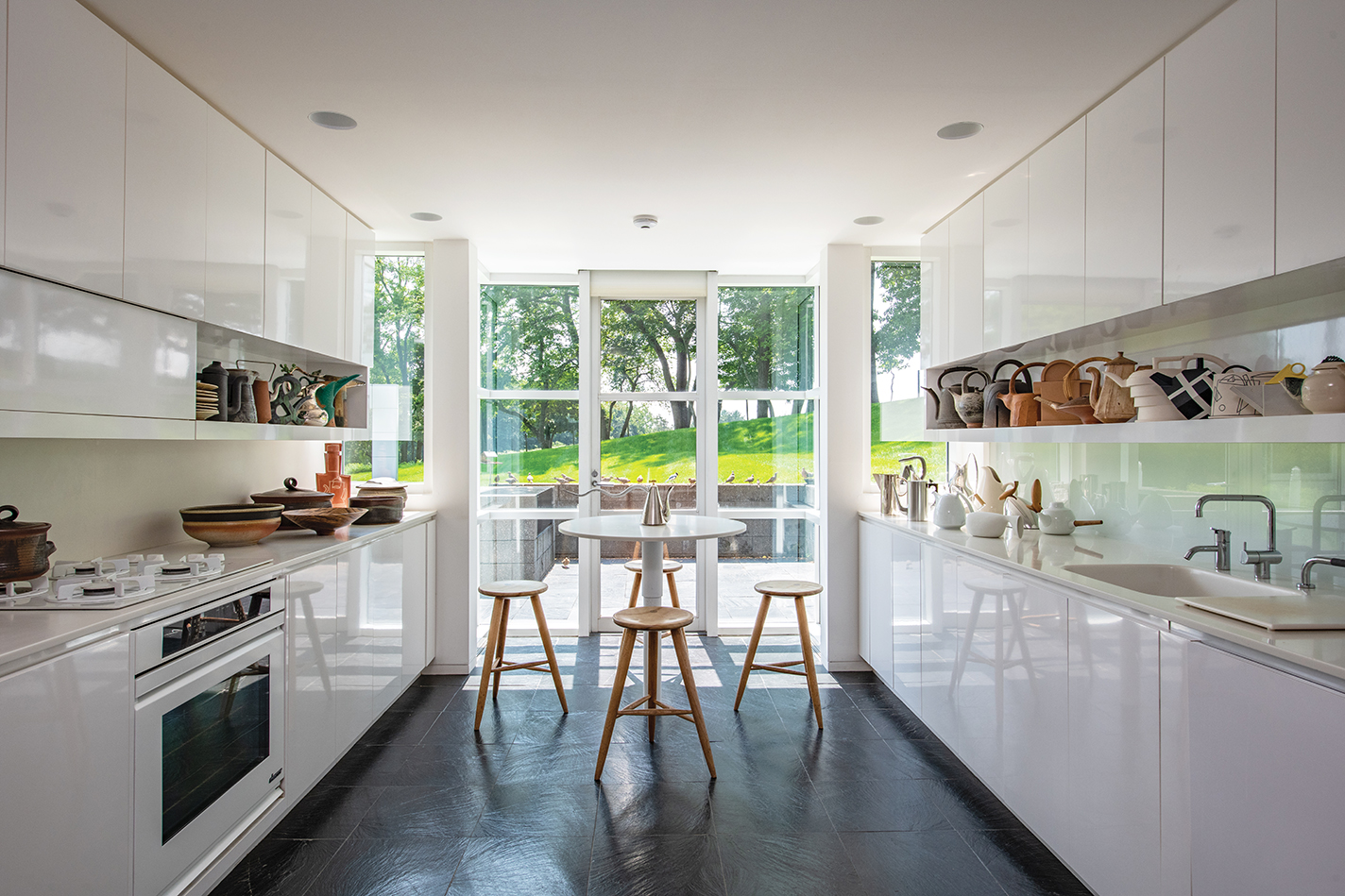 A view of the kitchen with many handmade teapots and bowls.