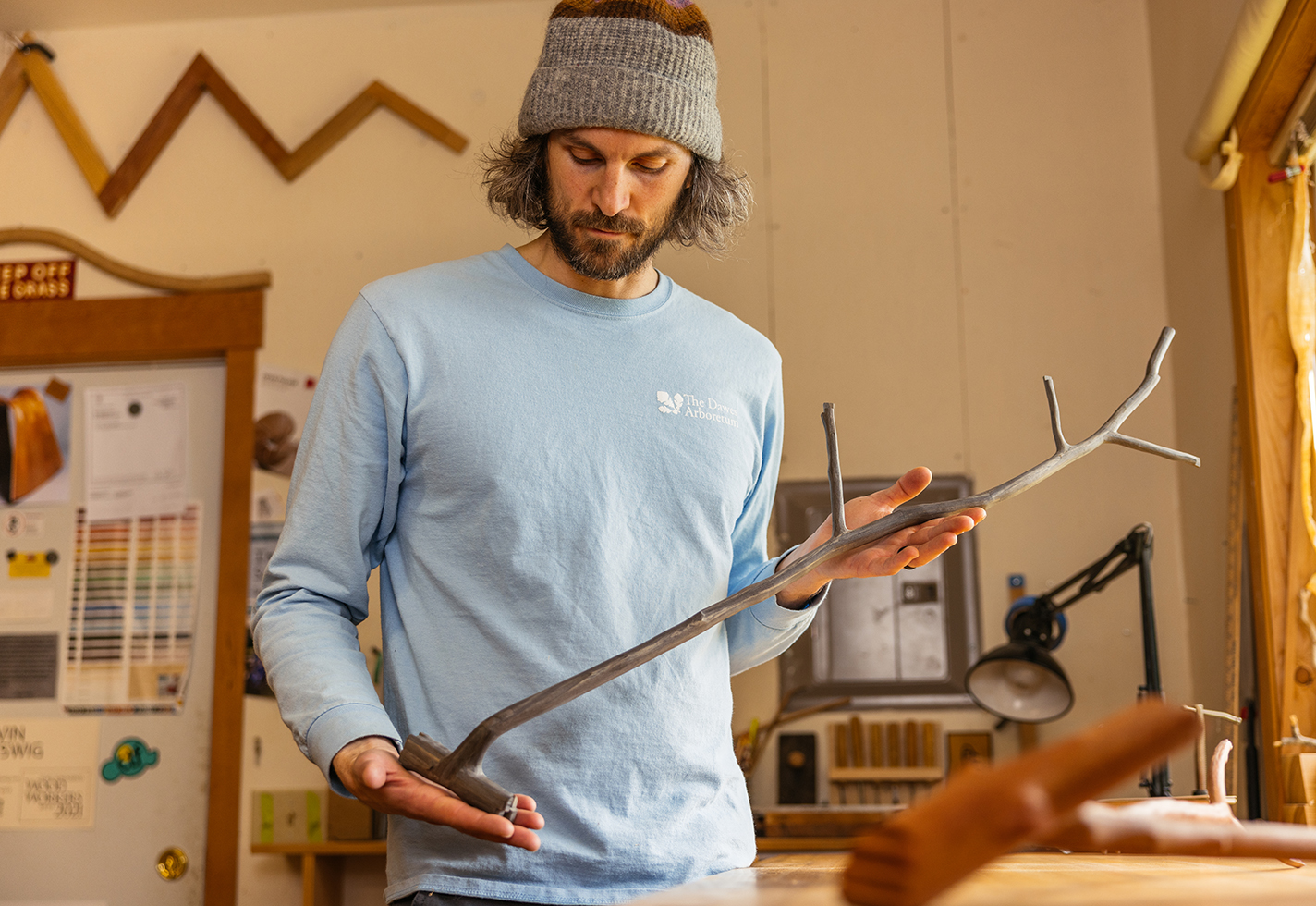 Kevin Reiswig holds a tree branch-shaped sculpture crafted from reclaimed wood at his studio in Port Townsend, Washington.