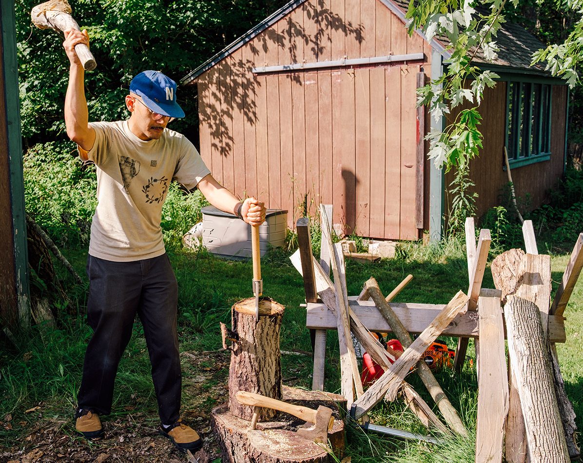 Thompson splits wood outside his studio.