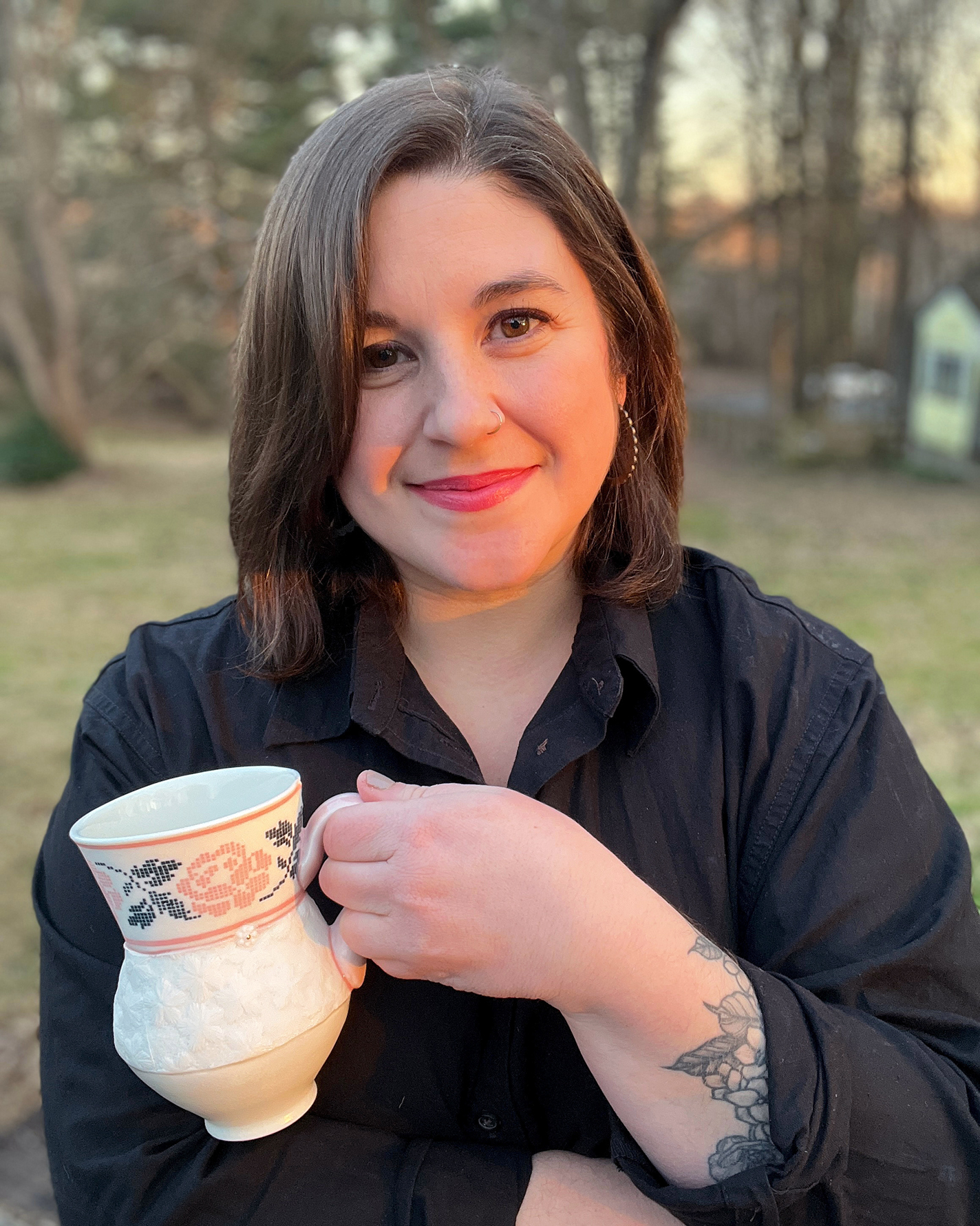Samantha Briegel holds a cross-stitch dimple mug on her farmhouse porch.