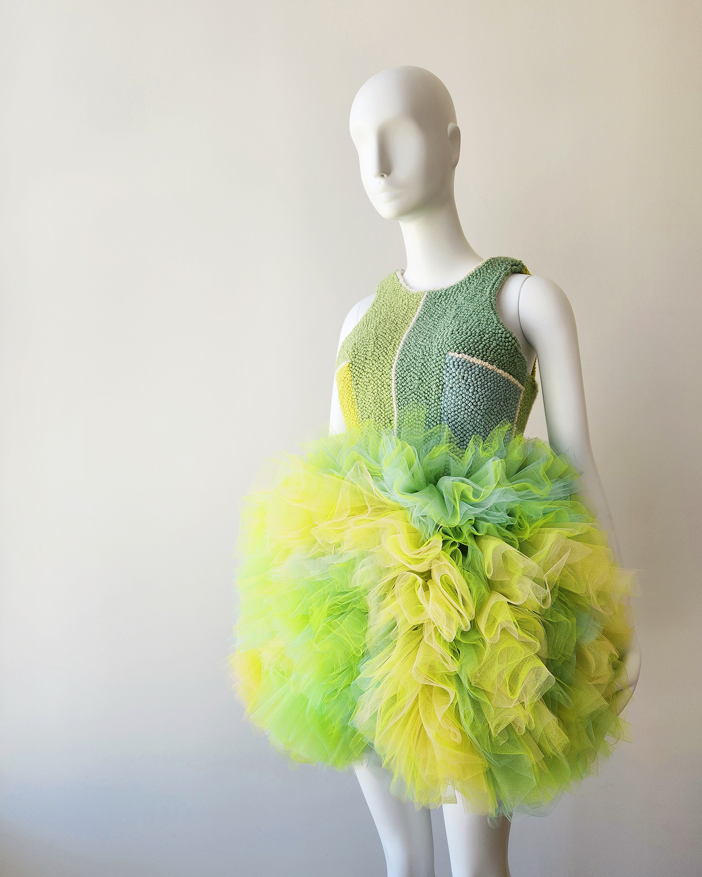 Green, blue, and yellow party dress with punch needle body and tulle skirt.
