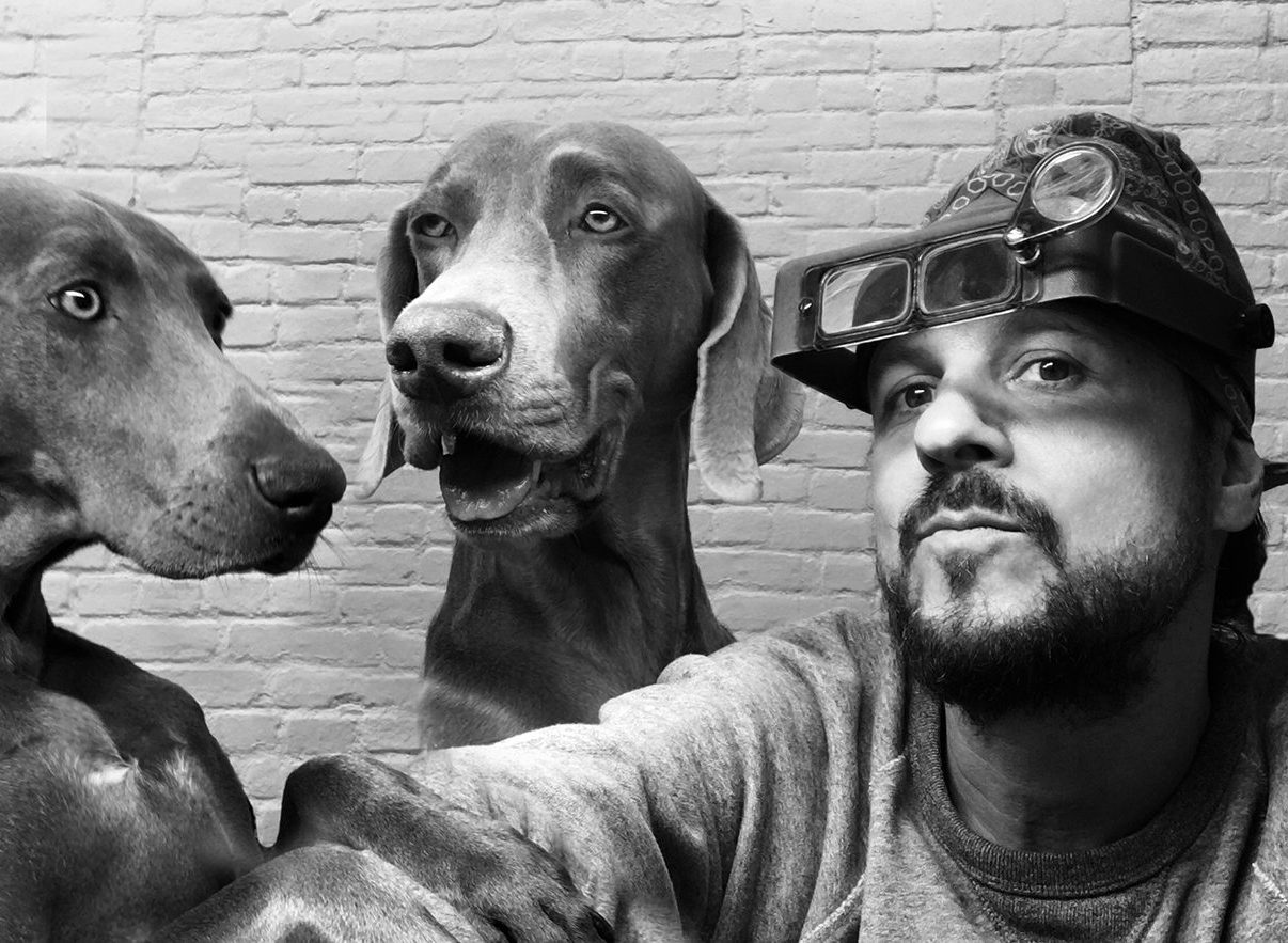 Bliven in his workshop with his two dogs.