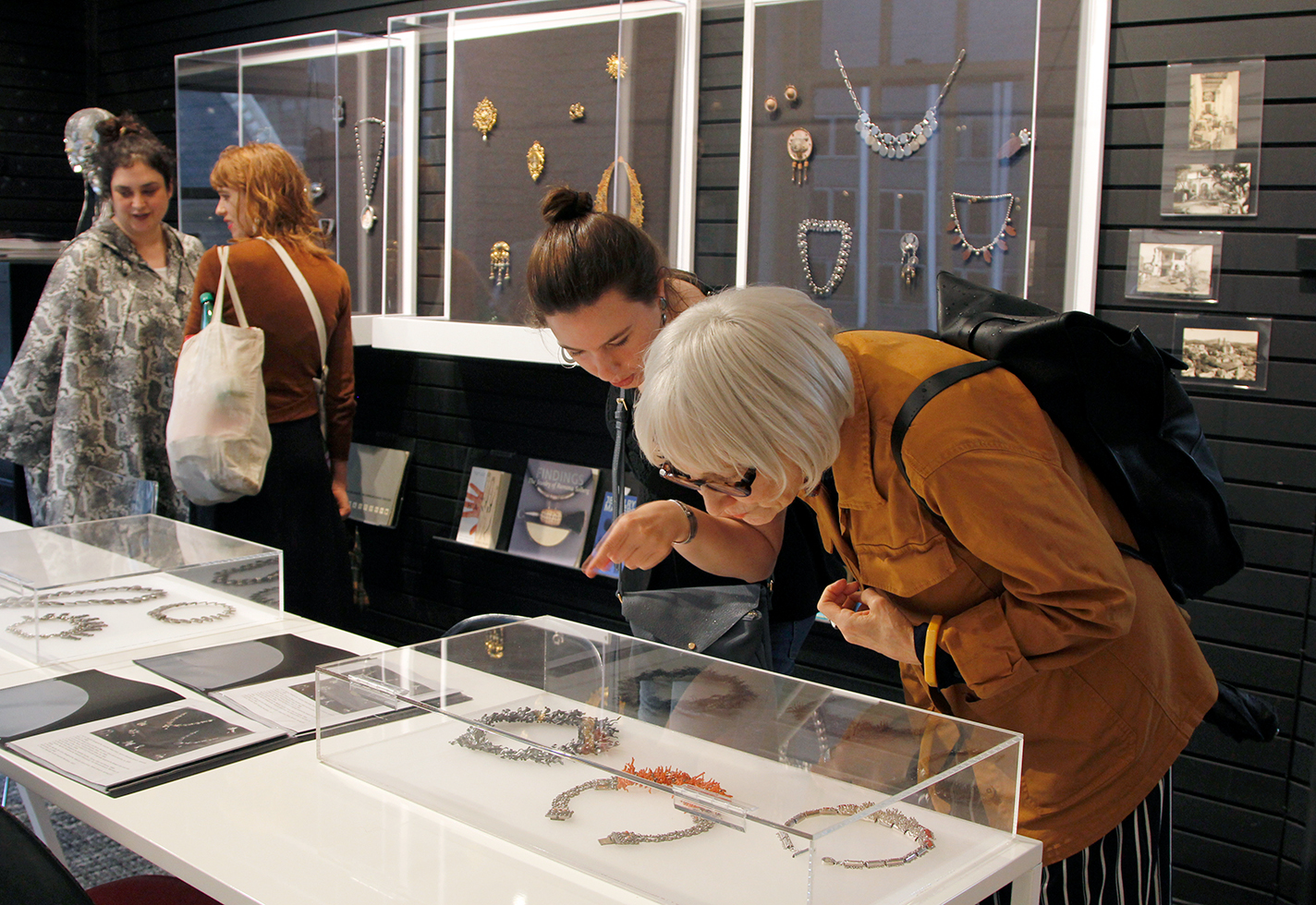 Visitors look at jewelry in an exhibition.