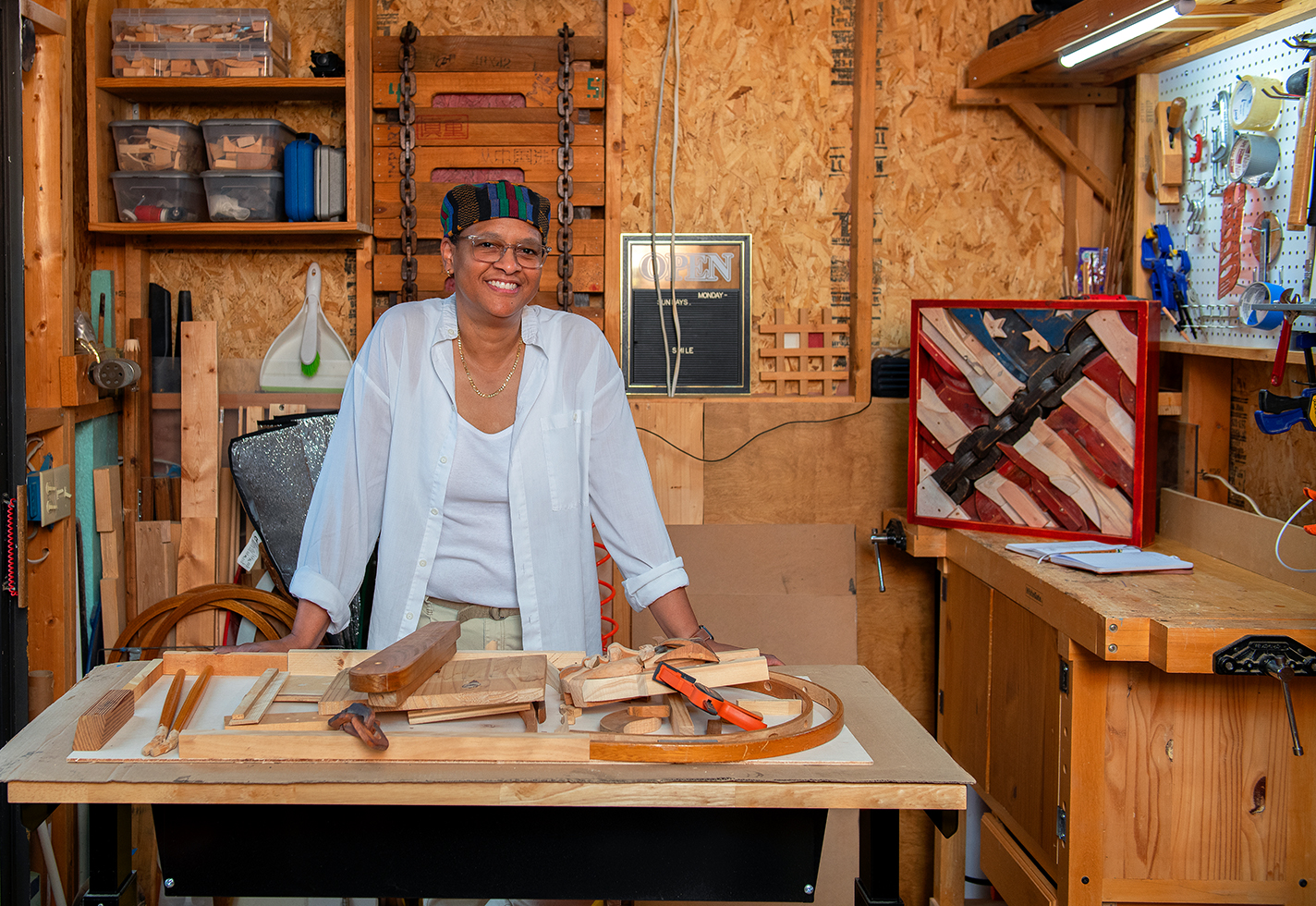 Felicia Greenlee in her shop with wood collage in the background.