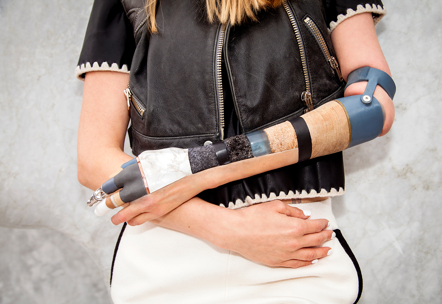 Kelly Knox wears a prosthetic arm made with silicone and interchangeable steel, rock, earth, wood, moss, oil, cork, wool, bronze, rhodium, and gold parts.