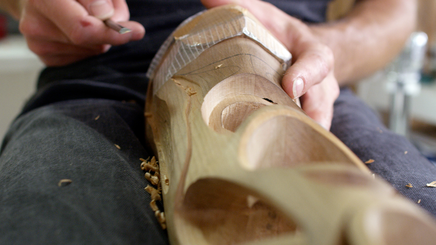 Wood-carver working on prosthetic leg.