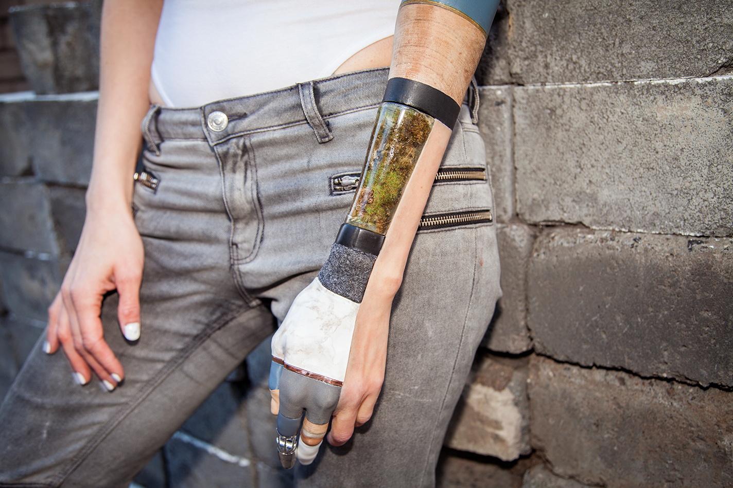 Kelly Knox wears a prosthetic arm made with silicone and interchangeable steel, rock, earth, wood, moss, oil, cork, wool, bronze, rhodium, and gold parts.